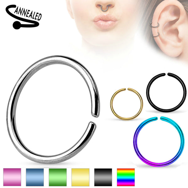 Word annealed in left corner and product models in right corner showing this ring worn in a septum and helix piercing. A round seamless ring shown in steel, blue, green. gold, black, and rainbow color boxes.